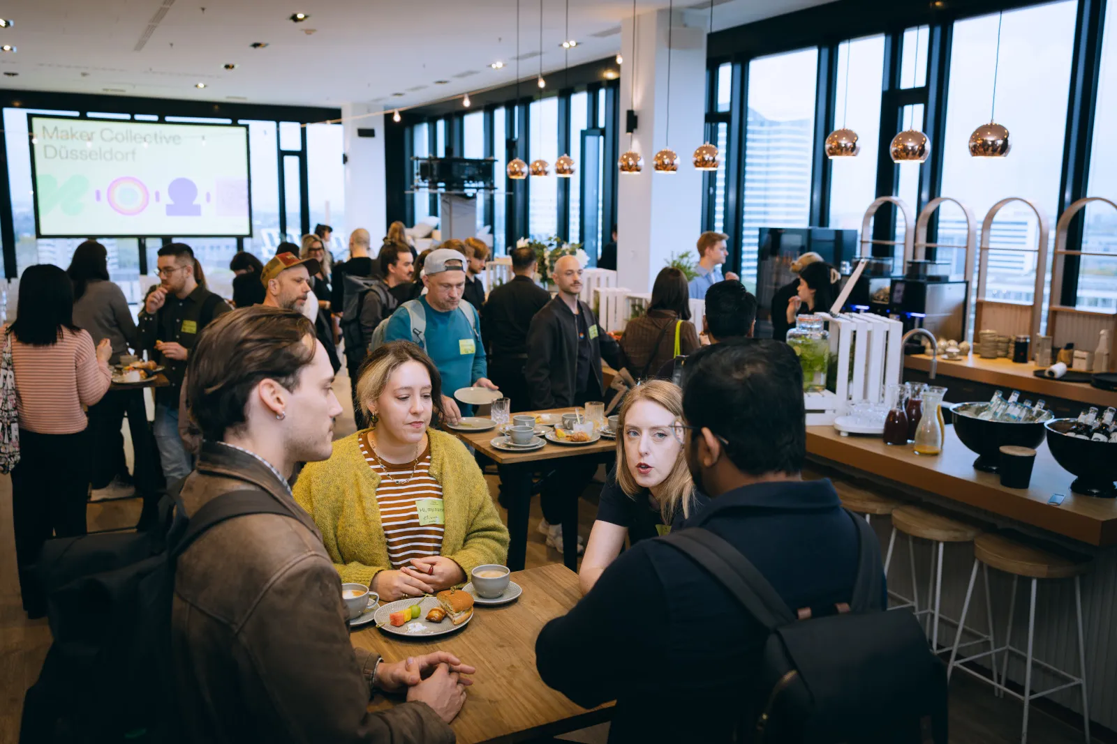 Networking-Bereich beim Figma Maker Collective Düsseldorf: Designer:innen und Developer:innen im Austausch bei Kaffee und Croissants.