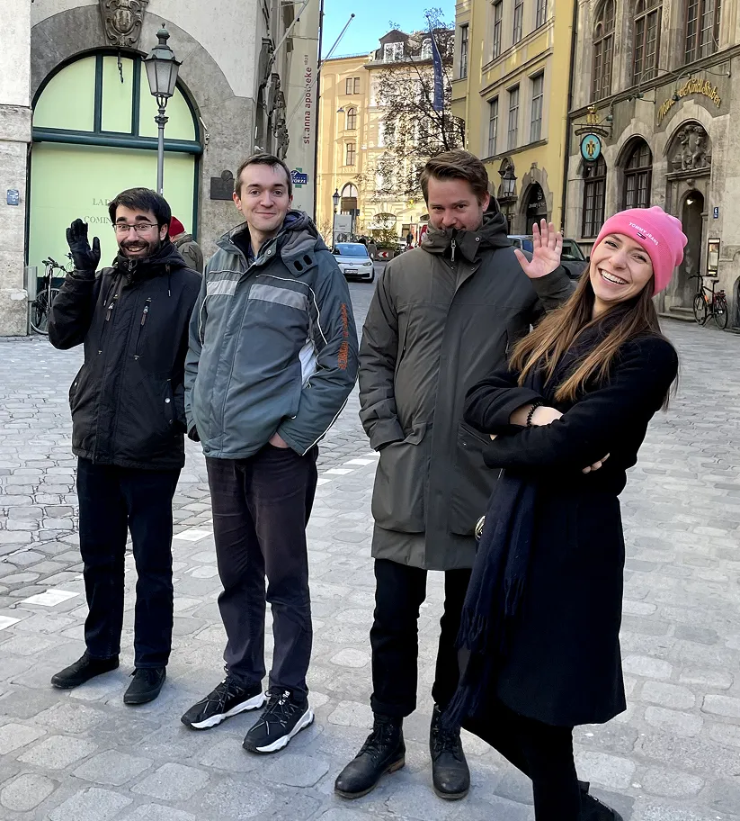 Julian steht mit Kolleg:innen in einer sonnigen Altstadtstraße, alle lachen und winken. Ein spontaner Schnappschuss, der das Teamgefühl bei appsoluts zeigt.